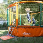 Children playing trampoline in the playground of camping Pré des moines