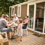 Family on a terrace of a mobile home at camping Pré des moines